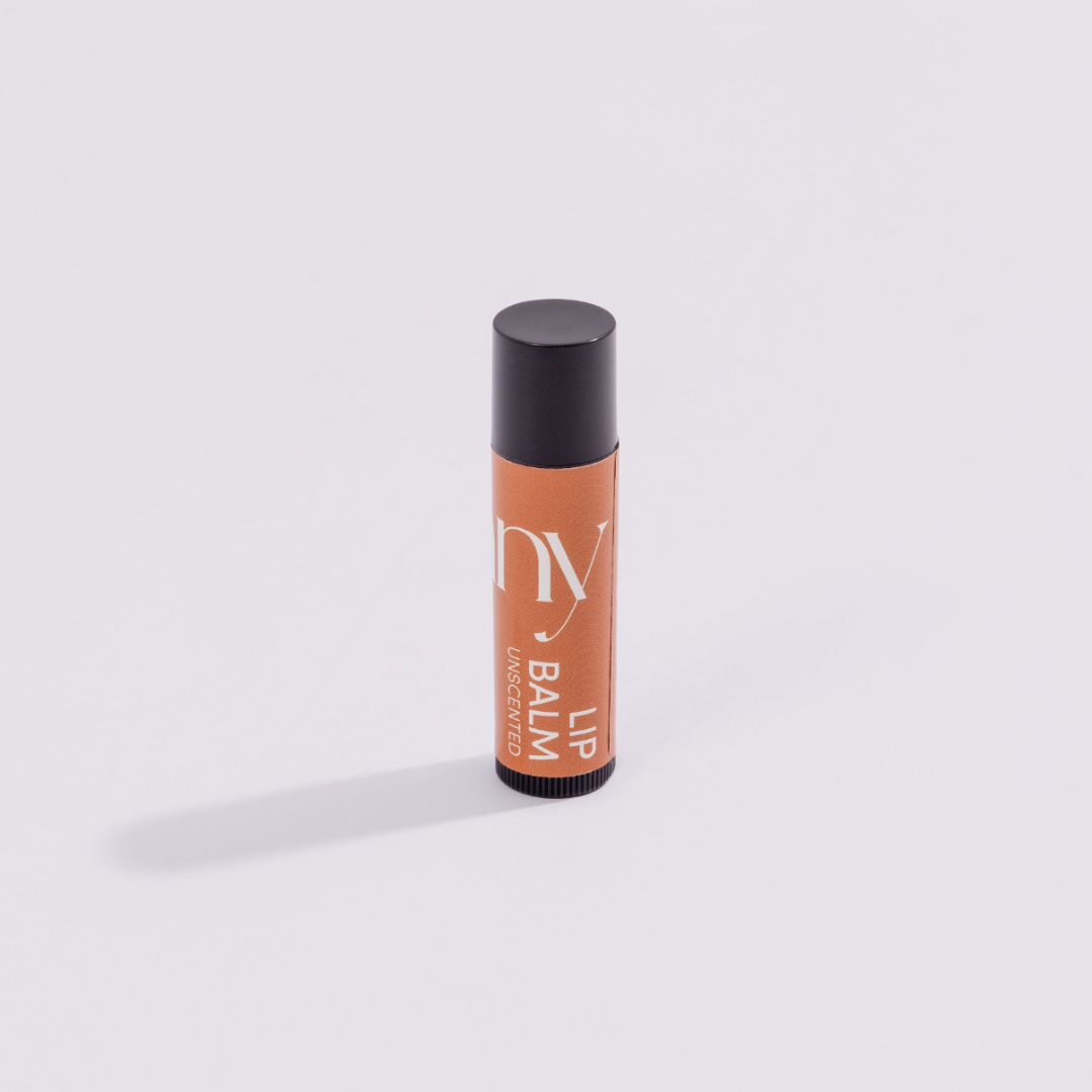 Lip balm with black cap and orange body on a white background